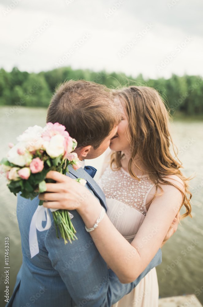 Happy wedding couple hugging and smiling each other on the background lake, forest Happy wedding couple hugging and smiling each other on the background lake, forest