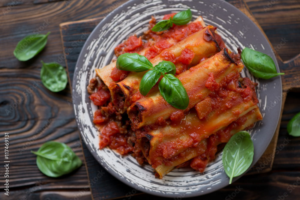 Above view of baked cannelloni with minced meat and tomato sauce Above view of baked cannelloni with minced meat and tomato sauce