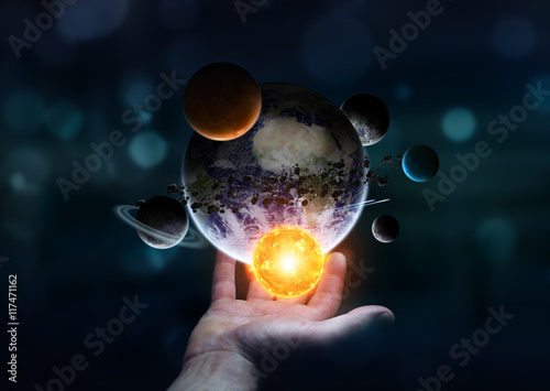 Businessman holding solar system in his hand