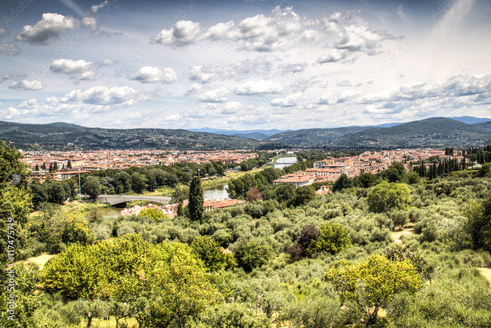 Fototapeta premium Magnificent view over the historical center of Florence in Italy. The photo is taken from piazzale Michelangelo and shows the Arno river, the Duomo and many other churches and buildings 