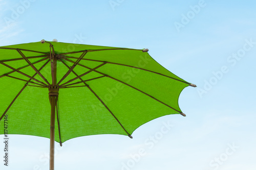 Traditional Asian paper and bamoo umbrella with a rounded handle on bluesky
