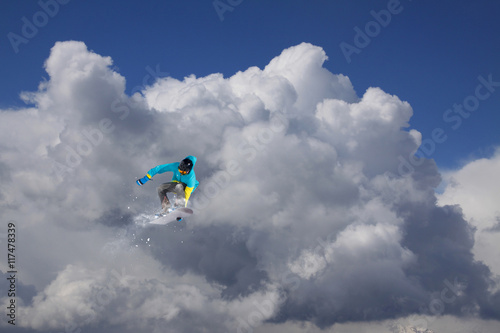 Snowboarder jumps on winter mountain.