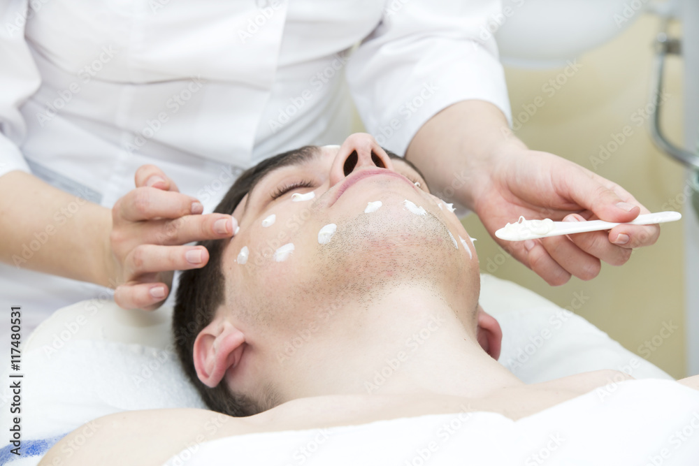 Naklejka premium man in the mask cosmetic procedure in spa salon