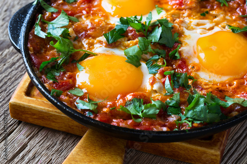 Egg dish with tomato sauce  served in  cast iron pan, shakshouka