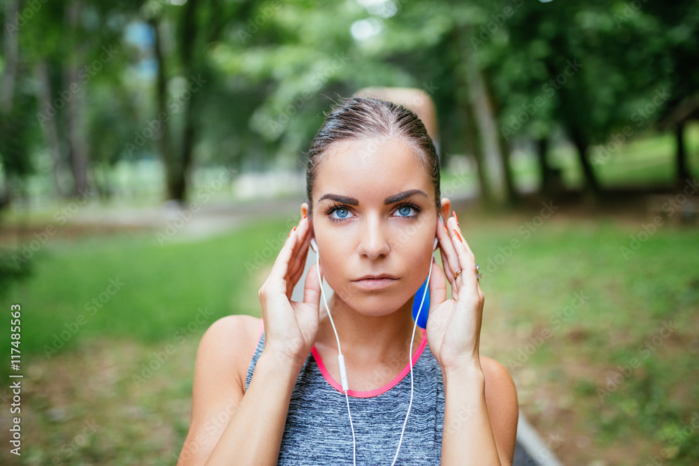 Attractive female sport fitness runner getting ready for jogging outdoors and listening to music. Attractive female sport fitness runner getting ready for jogging outdoors and listening to music.
