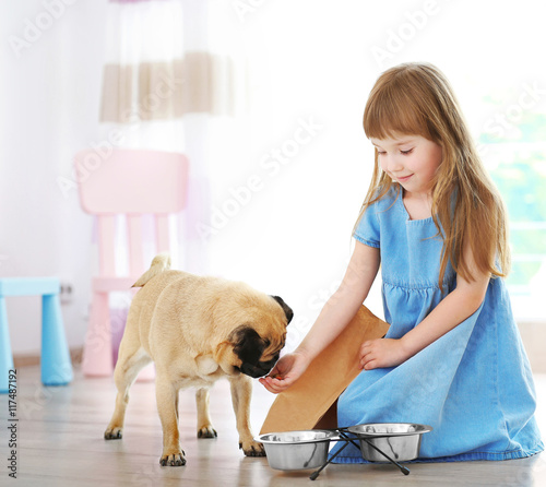 Adorable little girl feedin...
