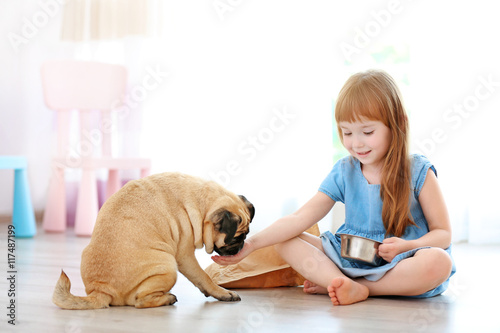 Adorable little girl feedin...