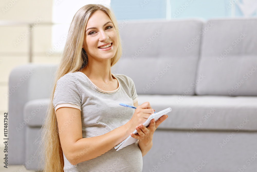Pregnant woman making packing list for maternity hospital at home Pregnant woman making packing list for maternity hospital at home