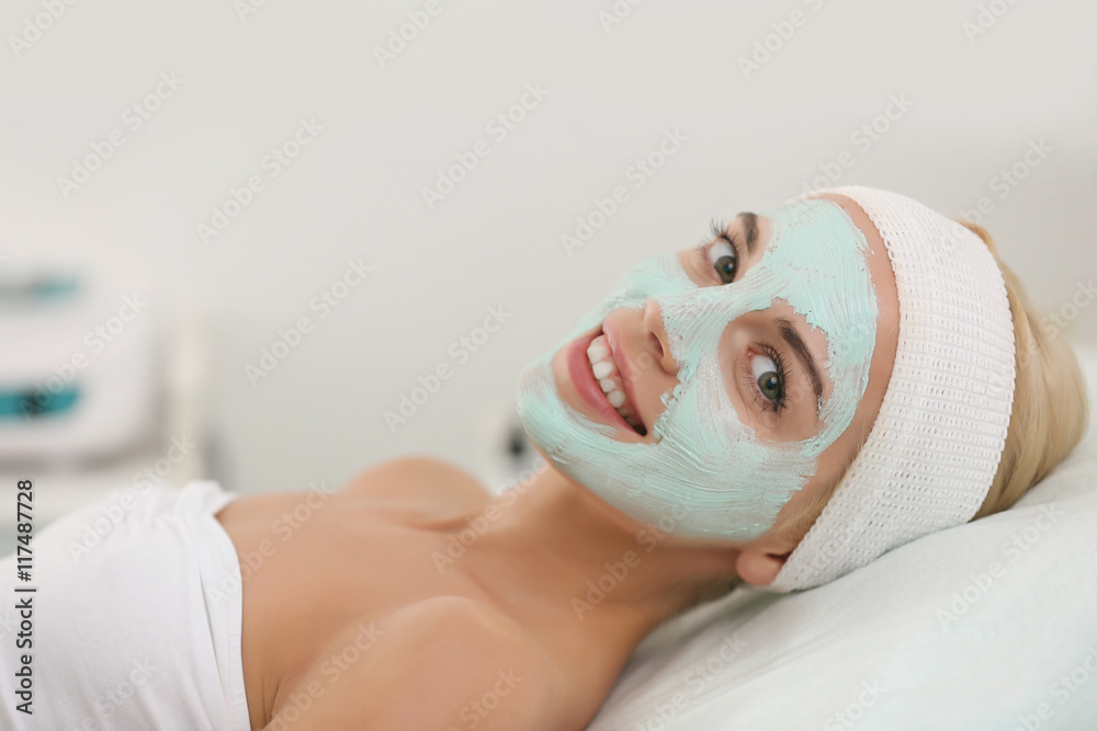 Young woman with facial mask at cosmetologist