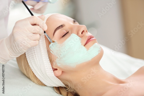Cosmetologist applying faci...