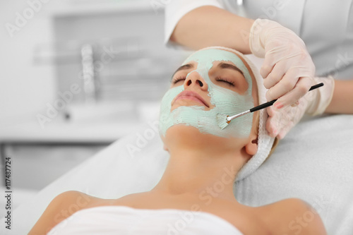 Cosmetologist applying faci...