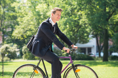 Businessman Riding Bicycle In Park