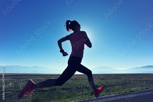  young fitness woman runner running on sunrise seaside trail