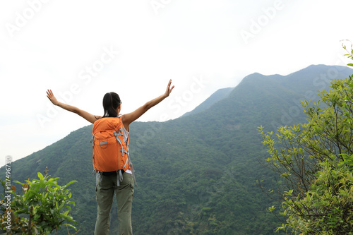 young woman backpacker hiking at forest mountain top