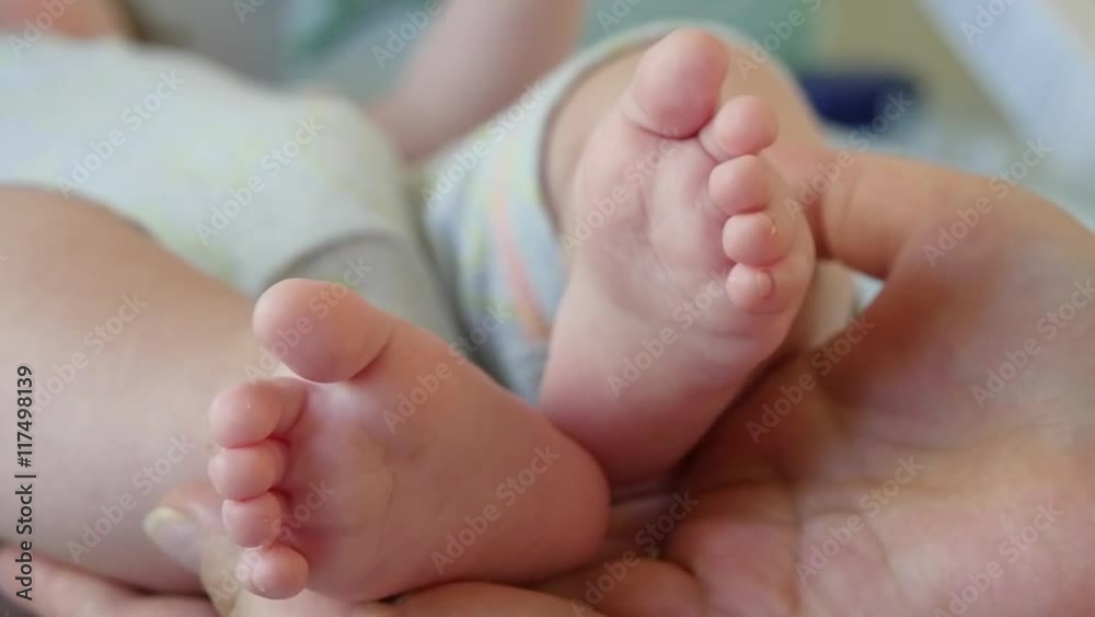 Slow motion shot of a foot the baby in adult hands Slow motion shot of a foot the baby in adult hands