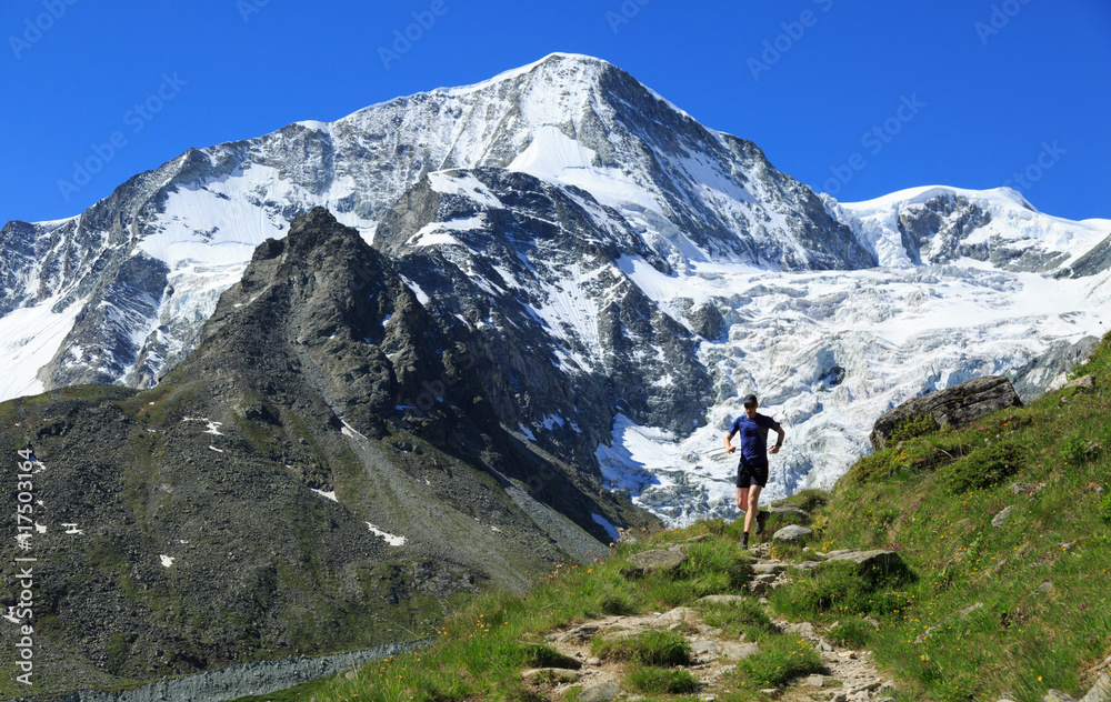 Athlete trail running in the beautiful mountains of Arolla, Switzerland. Sports and healthy lifestyle concept.