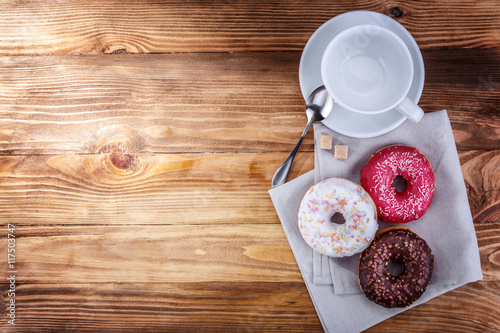 white mug grain coffee and donuts on a wooden background