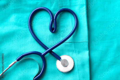 stethoscope shaping  heart and  clipboard on  medical uniform, closeup photo