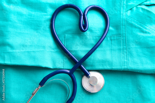 stethoscope shaping  heart and  clipboard on  medical uniform, closeup