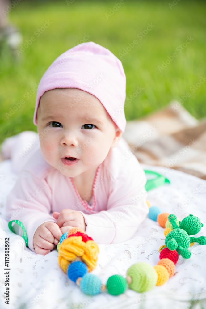 Baby girl crawling on the grass with sling beads Baby girl crawling on the grass with sling beads