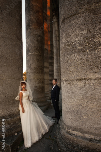 The lovely couple in love stand near coloums photo