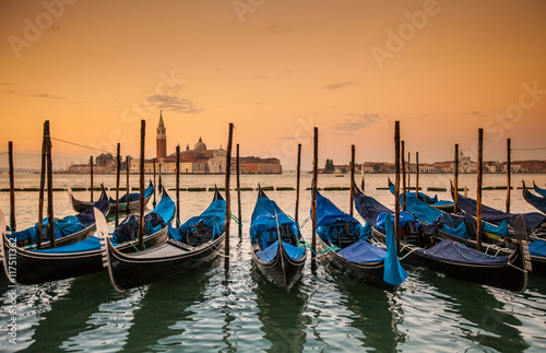 Gondolas moored by Saint Mark square - Venice during sunrise, Italy, Europe.