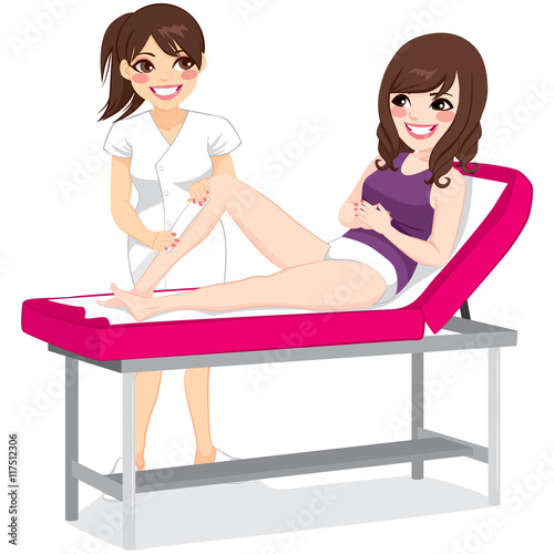Beautiful beautician waxing young woman legs lying on spa bed