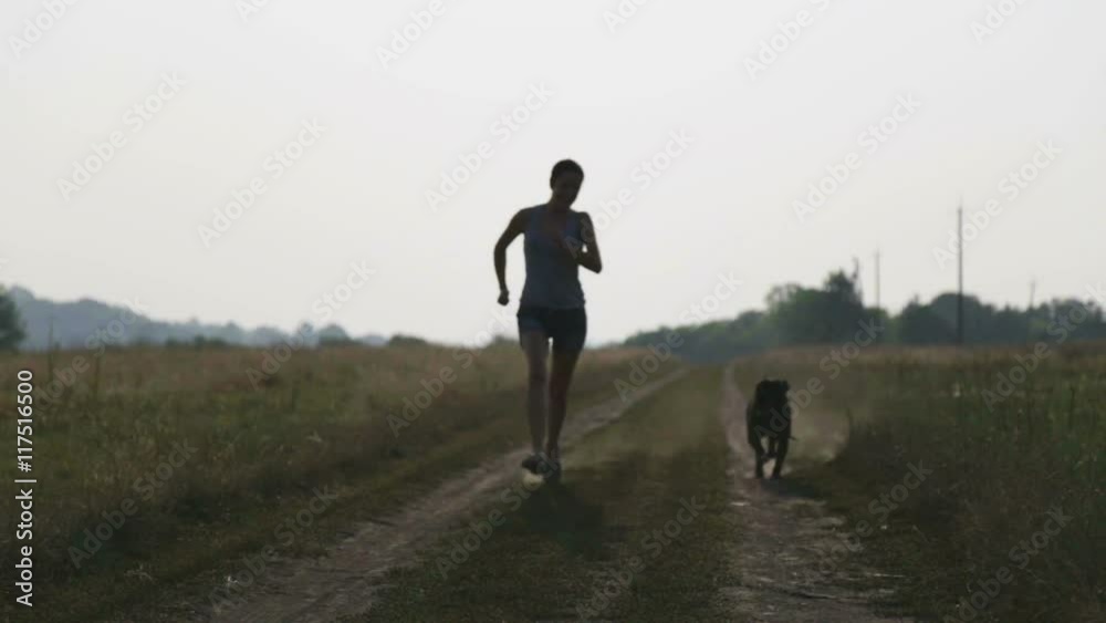 Young woman with dog in the nature. Girl walking a terrier in a field.
Young woman with dog in the nature. Girl walking a terrier in a field.