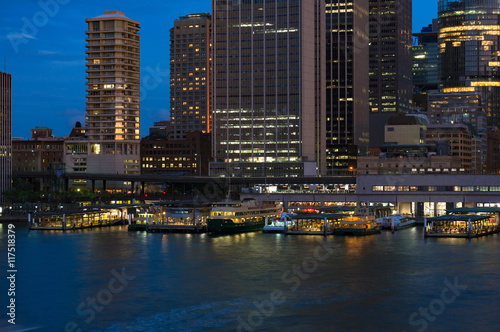 Circular Quay railway, train station and ferry wharfs with Sydney Central Business District cityscape skyscrapers at the background. Night shot, long exposure, copy space