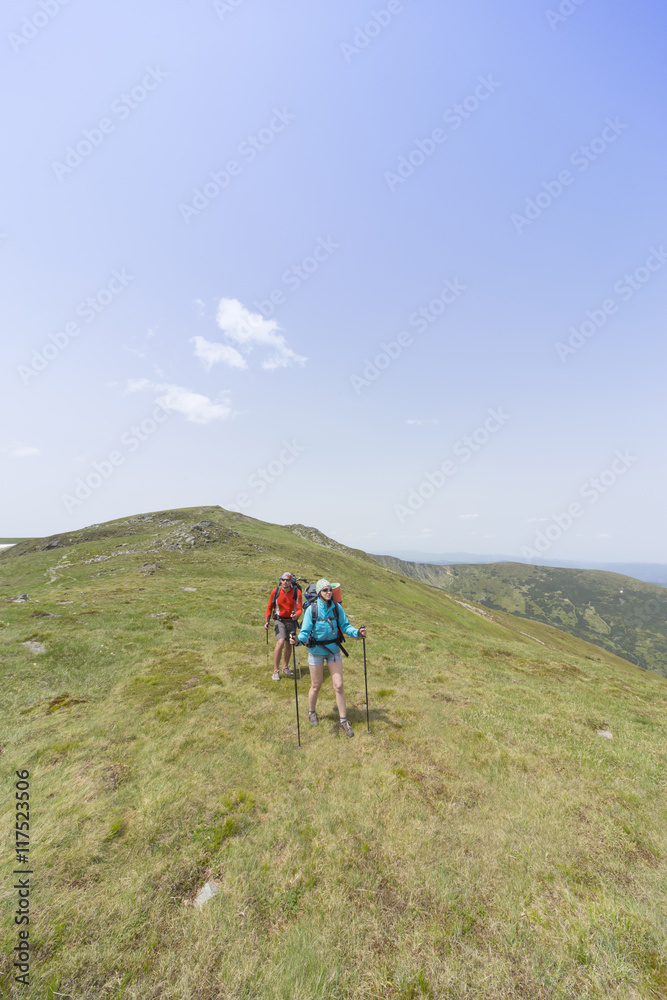 Obraz premium Summer hiking in the mountains with a backpack .