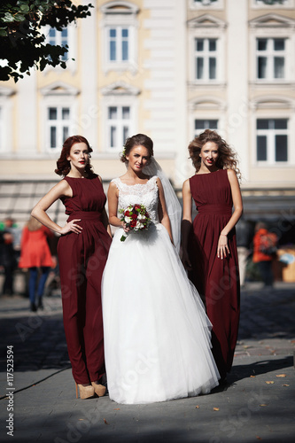 The bridesmaids with bride stand in the center of town
