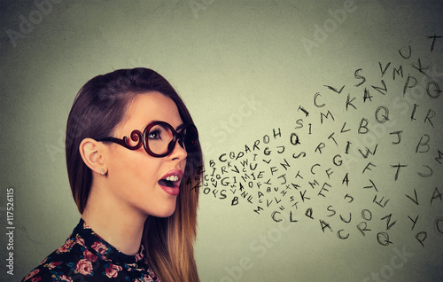 Woman in glasses talking with alphabet letters coming out of her mouth