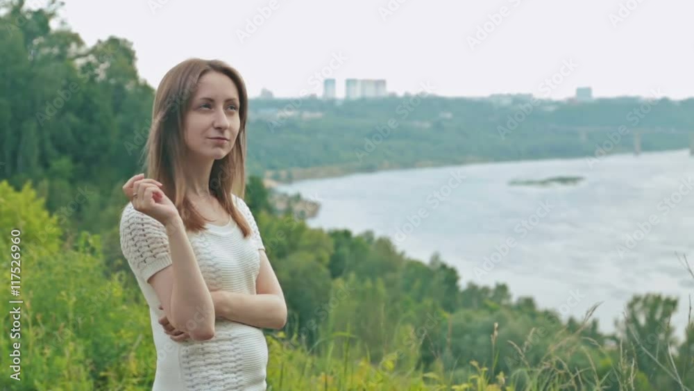 Young woman in embankment, hair blowing in wind Young woman in embankment, hair blowing in wind