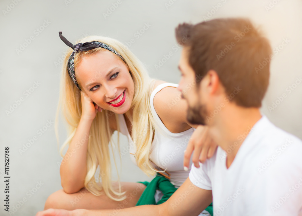 Happy young couple in love sitting on a bench Happy young couple in love sitting on a bench