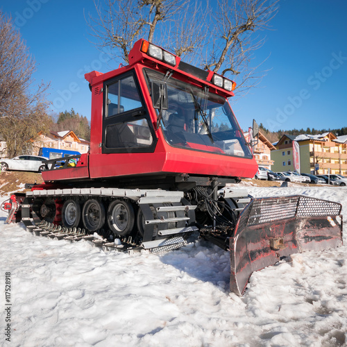 Snowmobile parked at the end of a ski slope.