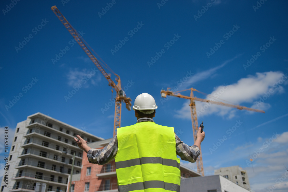 Foreman using walkie-talkie on construction site Foreman using walkie-talkie on construction site