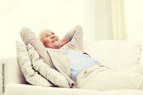 happy senior woman resting on sofa at home
