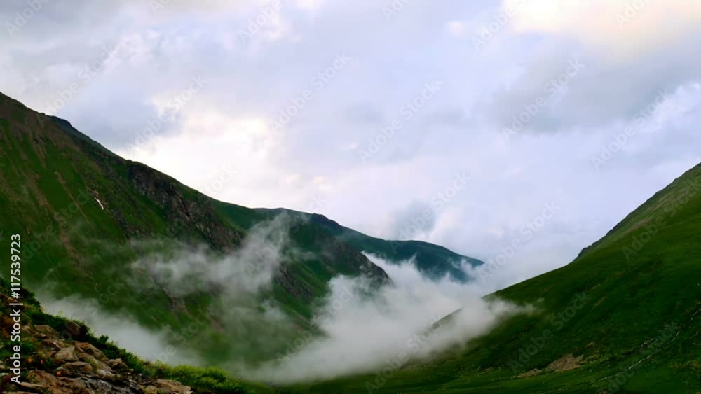 Time lapse of fog and clouds rolling over the mountain green hills Time lapse of fog and clouds rolling over the mountain green hills
