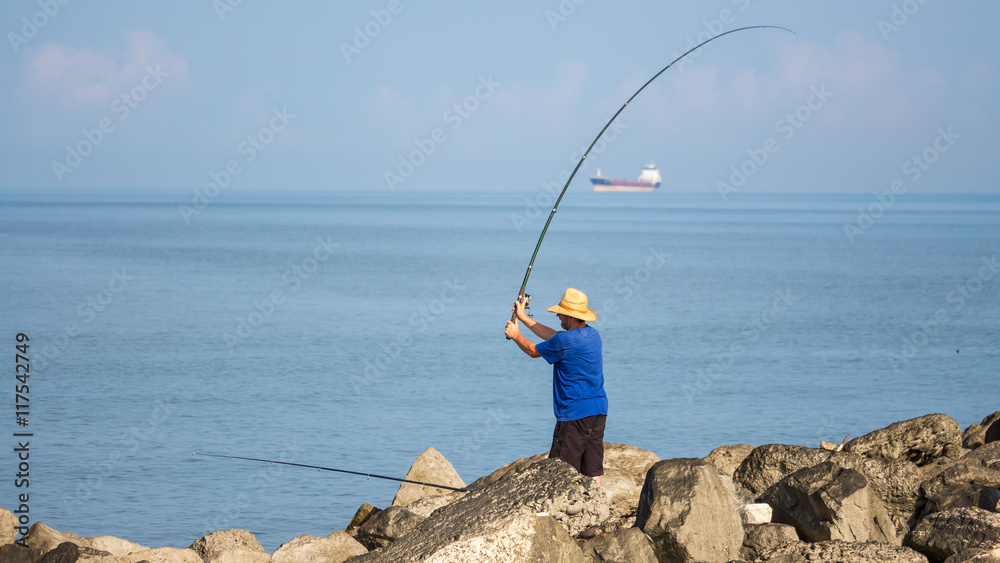 lone fisherman fishing with a fishing rod on the black sea, Poti