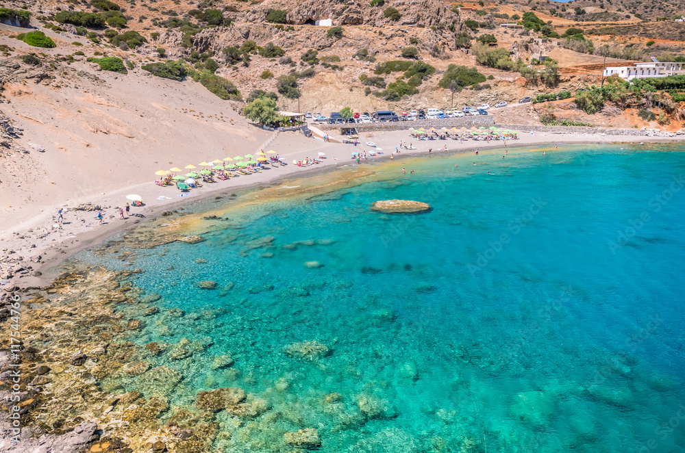 Agios Pavlos Beach in Crete island, Greece. Tourists relax and bath in crystal clear water of St. Paul Sandhill Beach.