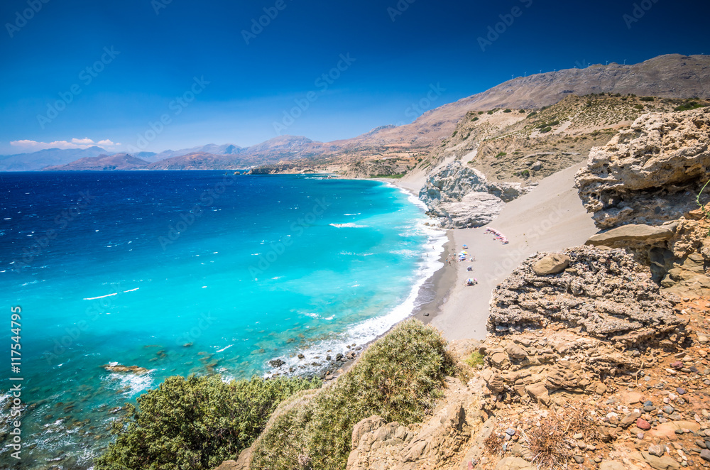 Agios Pavlos Beach in Crete island, Greece. Tourists relax and bath in crystal clear water of St. Paul Sandhill Beach. Agios Pavlos Beach in Crete island, Greece. Tourists relax and bath in crystal clear water of St. Paul Sandhill Beach.
