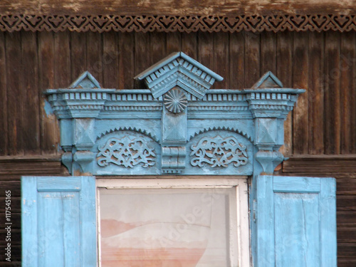The windows with beautiful architraves in old wooden house. Ulan