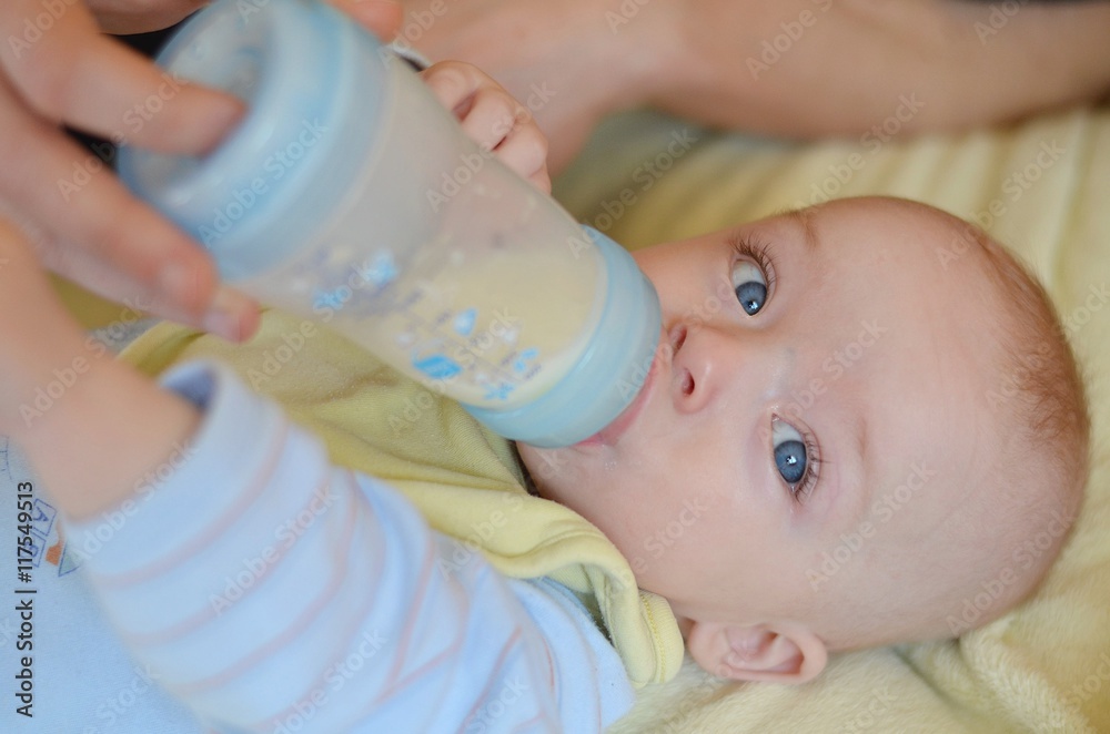 Baby is drinking infant milk from the bottle which parent´s hand holds. Baby is drinking infant milk from the bottle which parent´s hand holds.