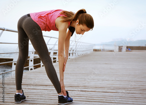 Young woman doing exercises on pier