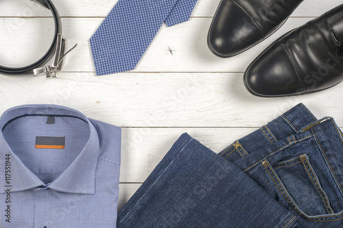 set of men's clothing and shoes on wooden background.