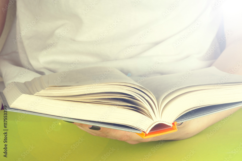 Young girl reading an open old book. Knowledge, Science. Toned image. Young girl reading an open old book. Knowledge, Science. Toned image.