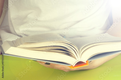 Young girl reading an open old book. Knowledge, Science. Toned image.