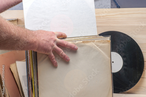 Browsing through vinyl records collection. Music background. Copy space