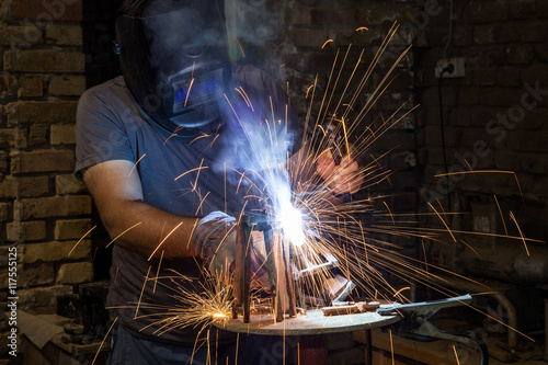 welder artist welds metal frame