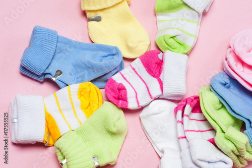 Cotton baby socks for newborn on a colorful pink background. Copy space for text. Top view